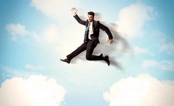 Деловой человек, прыгающий через облака в небе — стоковое фото