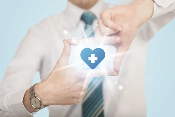 Mani che creano una forma con croce blu cuore — Foto Stock
