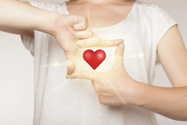Mãos criando uma forma com coração brilhante — Fotografia de Stock