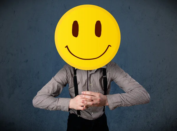 Επιχειρηματίας κρατώντας ένα χαμογελαστό φατσούλα emoticon — Φωτογραφία Αρχείου