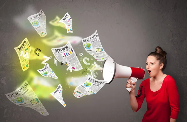 Girl yelling into loudspeaker and newspapers fly out — Stock Photo, Image