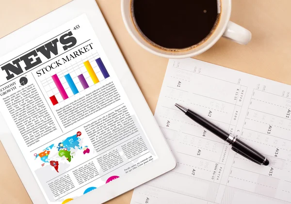 Tablet pc shows news on screen with a cup of coffee on a desk — Stock Photo, Image