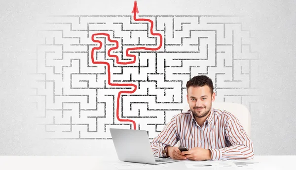 Affärsman på skrivbord med labyrint och pilen — Stockfoto