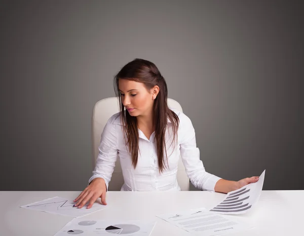 Mulher de negócios sentada na mesa e fazendo papelada — Fotografia de Stock