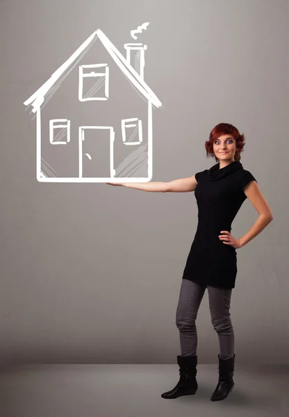 Fiatal hölgy kezében egy hatalmas rajzolt ház — Stock Fotó