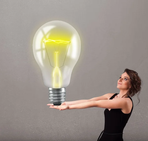 Beautiful lady holding realistic 3d light bulb — Stock Photo, Image