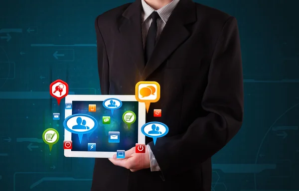 Uomo d'affari che presenta tablet moderno con segni sociali colorati — Foto Stock