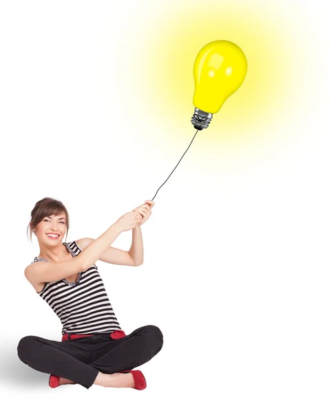 Happy woman holding a light bulb balloon — Stock Photo, Image