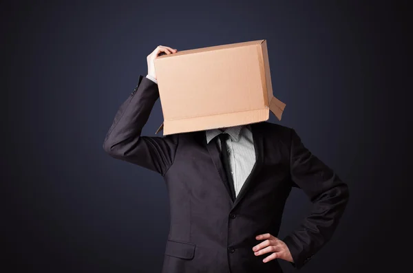 Businessman gesturing with a cardboard box on his head — Stock Photo, Image