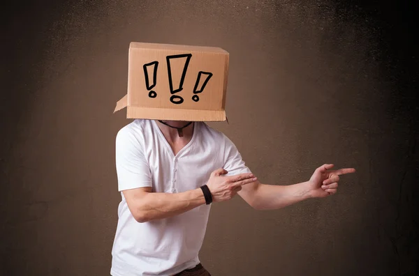 Молодой человек жестом с картонной коробкой на голове с восторгом — стоковое фото