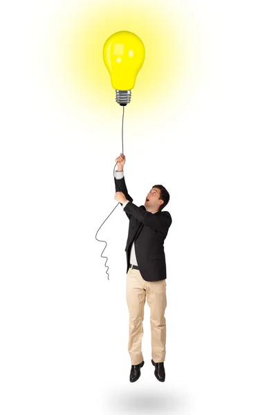 Homem feliz segurando um balão lâmpada — Fotografia de Stock