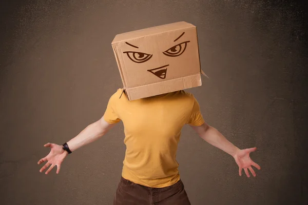Jovem gesticulando com uma caixa de papelão em sua cabeça com f mal — Fotografia de Stock