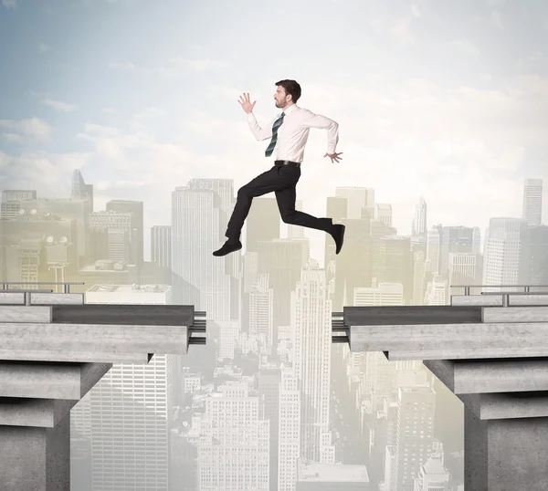 Energetische zakenman springt over een brug met kloof — Stockfoto