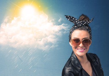 Güneş gözlükleriyle bulutlara ve güneşe bakan genç adam