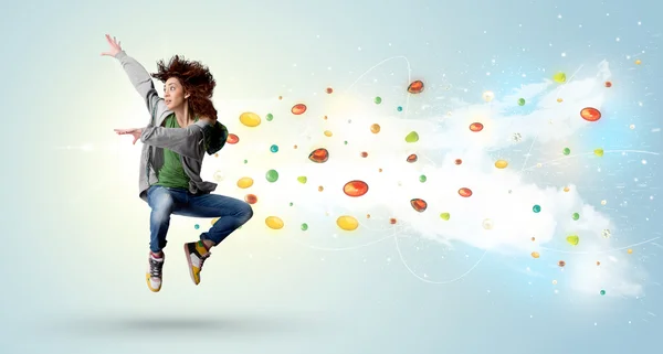 Beautiful woman jumping with colorful gems and crystals on the b — Stock Photo, Image