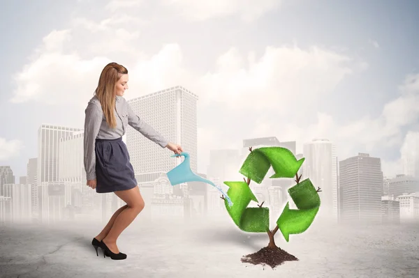 Mulher de negócios molhando árvore sinal de reciclagem verde no backgrou da cidade — Fotografia de Stock