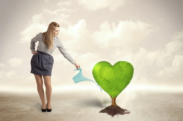 Mulher de negócios molhando coração em forma de árvore verde — Fotografia de Stock