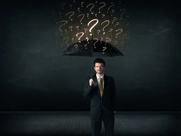 Homme d'affaires avec parapluie et beaucoup de points d'interrogation tirés — Photo