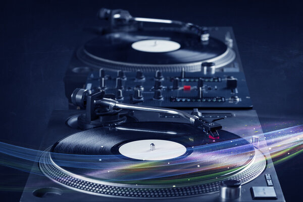 Музыкальный проигрыватель играет виниловую музыку с красочными абстрактными линиями