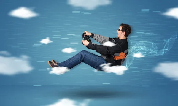 Funny racedriver young man driving between clouds concept — Stock Photo, Image