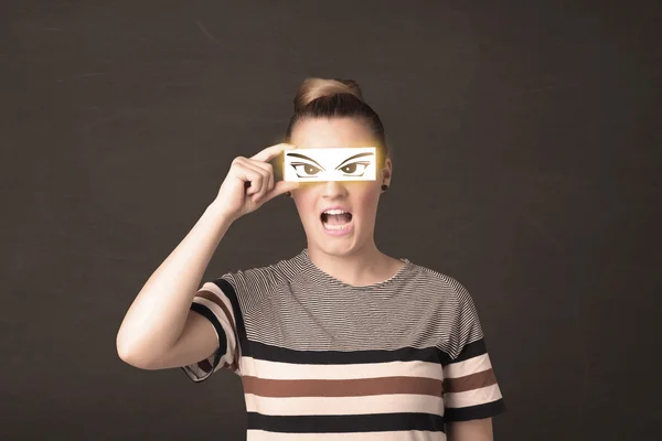 Joven guay mirando con un papel dibujado a mano ojos —  Fotos de Stock