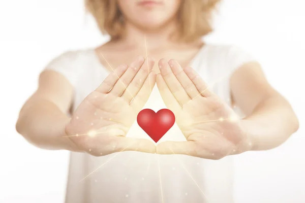 Manos creando una forma con un corazón brillante — Foto de Stock