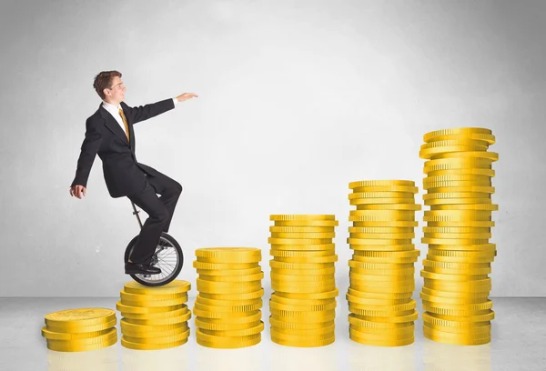 Business man riding monocycle up on coin graph — Stock Photo, Image