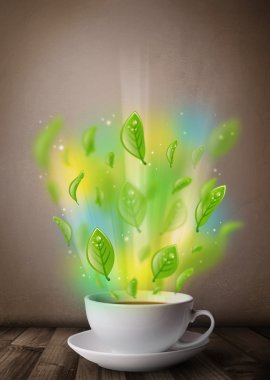 Yapraklı çay fincanı ve renkli soyut ışıklar