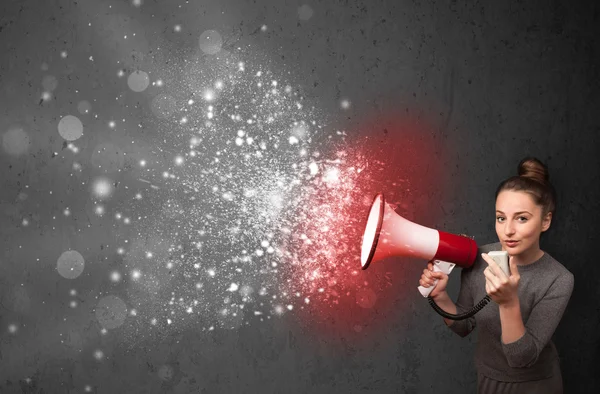 Woman shouting into megaphone and glowing energy particles explo — Stock Photo, Image