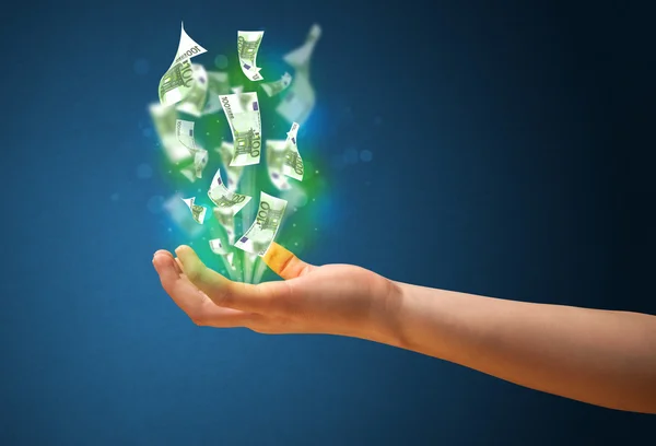 Glowing money in the hand of a woman — Stock Photo, Image