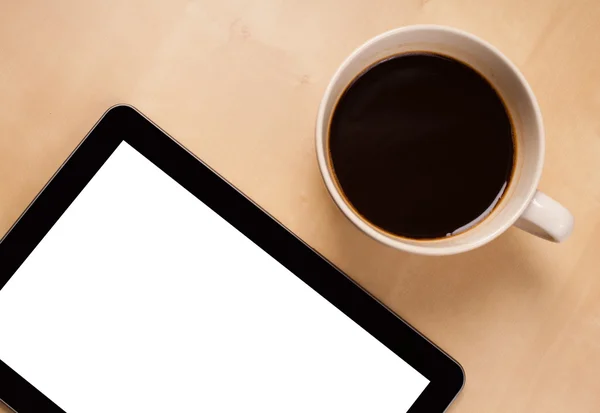 Tablet pc with empty space and a cup of coffee on a desk — Stock Photo, Image