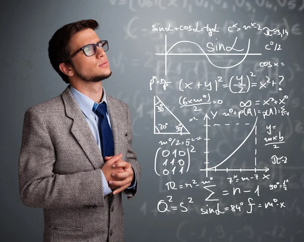 Snygg skolpojke tänker på komplexa matematiska tecken — Stockfoto