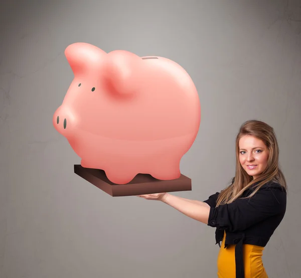 Young girl holding a huge savings piggy bank — Stock Photo, Image