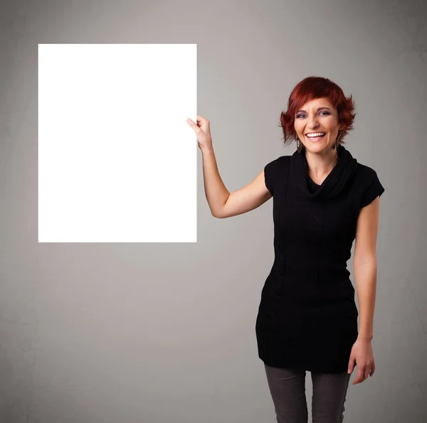 Young woman presenting white paper copy space — Stock Photo, Image