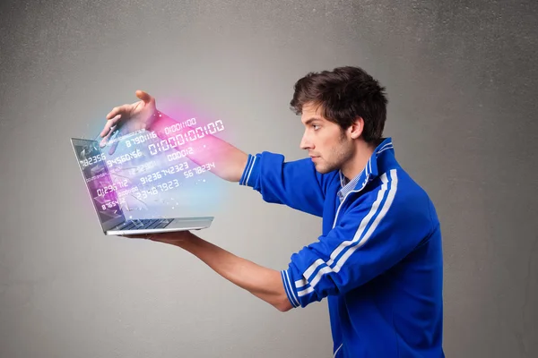 Casual man håller laptop med exploderande data och siffror — Stockfoto