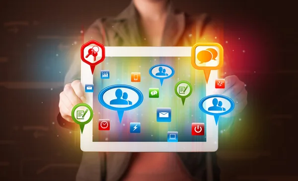 Girl presenting a tablet with colorful social icons and signs — Stock Photo, Image