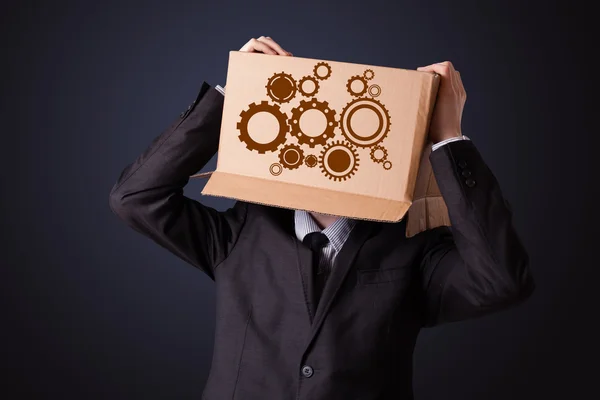 Young man gesturing with a cardboard box on his head with spur w — Stock Photo, Image