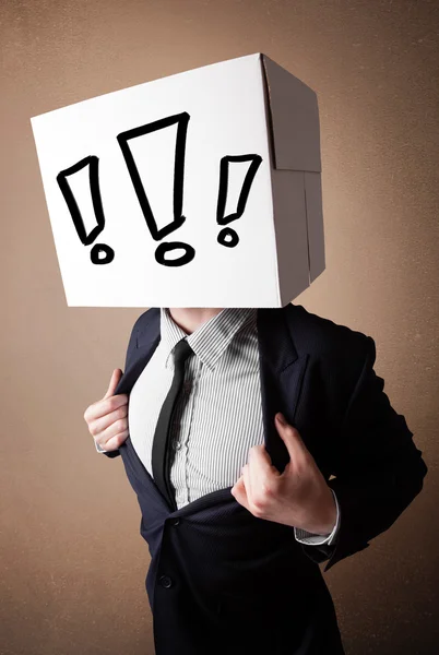 Businessman gesturing with a cardboard box on his head with excl — Stock Photo, Image