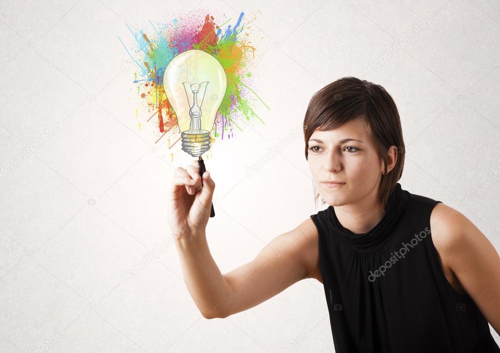 Young lady drawing a colorful light bulb with colorful splashes