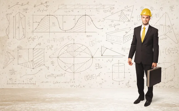 Handsome engineer calculating with hand drawn background — Stock Photo, Image