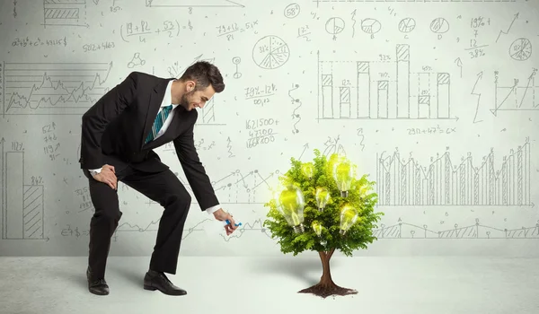 Business man pouring water on lightbulb growing tree — Stock Photo, Image