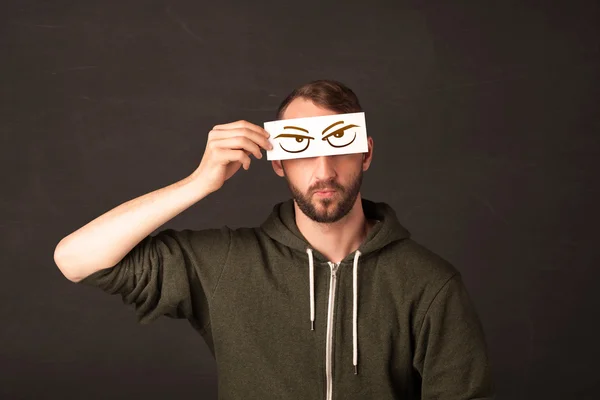 Young person holding paper with angry eye drawing — Stock Photo, Image