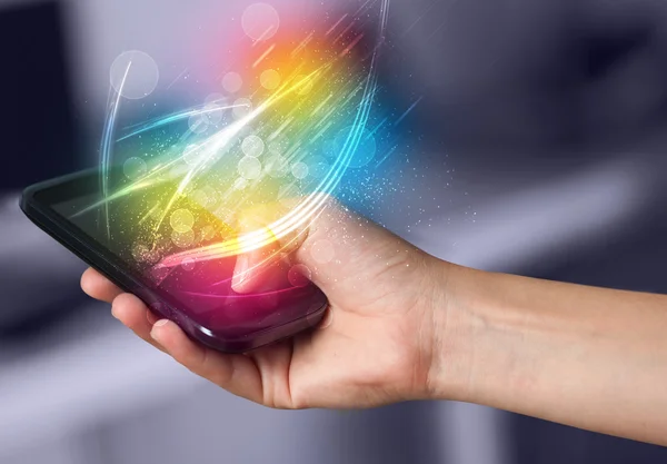 Ręczne trzymanie smartfona z abstrakcyjnymi, świecącymi liniami — Zdjęcie stockowe
