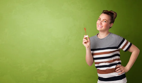 Hermosa mujer soplando burbuja de jabón sobre fondo de copyspace —  Fotos de Stock