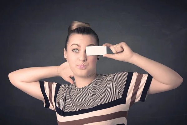 Pretty girl holding blank copy space paper at her eyes — Stock Photo, Image