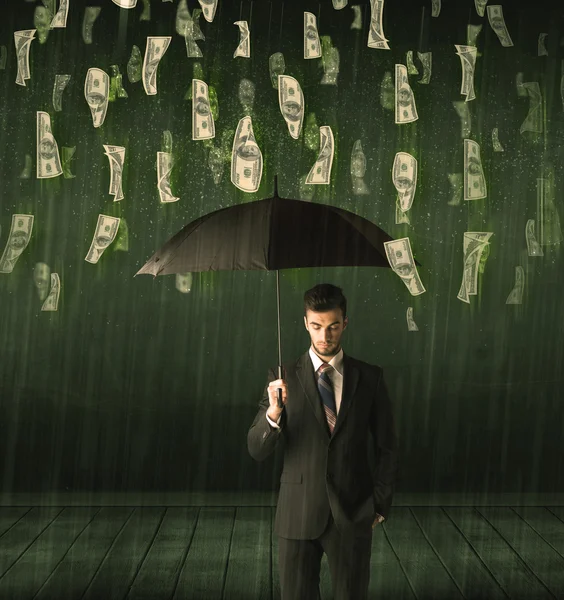 Businessman standing with umbrella in dollar bill rain concept — Stock Photo, Image