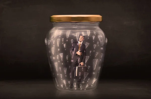 Business man trapped in jar with exclamation marks concept — Stock Photo, Image