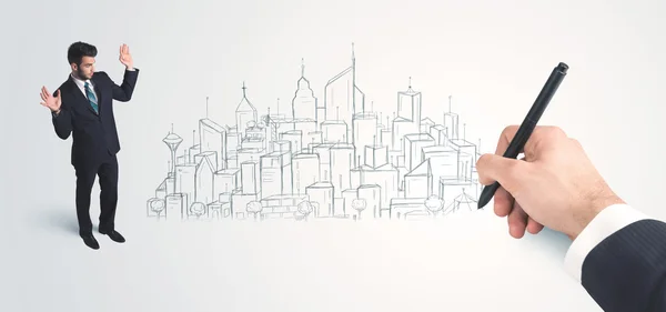 Businessman looking at hand drawn city on wall — Stock Photo, Image