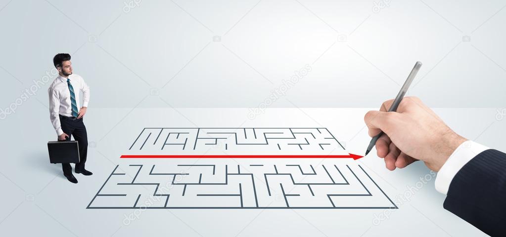 Business man looking at hand drawing solution for maze 