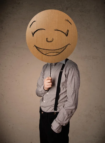 Affärsman som innehar en smiley face styrelse — Stockfoto